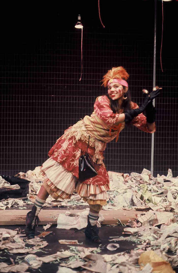 Sonia in Godspell dressed as gypsy amidst paper litter